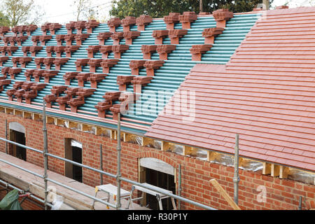 Un nuovo tetto è installato nel Regno Unito con la pianura rossa argilla piastrelle Foto Stock