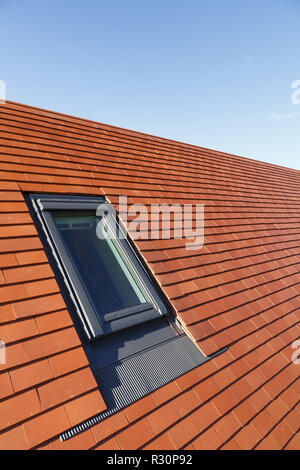 Luce del tetto Velux finestra di stile in una pianura tradizionali piastrelle in argilla tetto della casa Foto Stock
