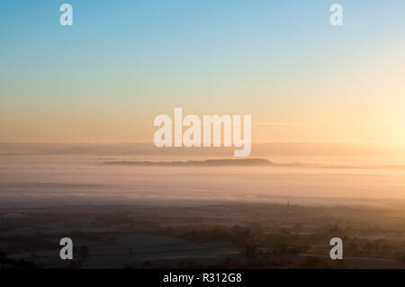 Sunrise su un bel pupazzo di neve, foschia mattutina. Guardando verso il basso su strati di nebbia attraverso la campagna inglese Foto Stock