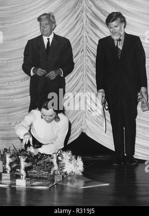 Noi attrice Shirley MacLaine ordina i numerosi orsi di Berlino dopo la cerimonia di premiazione del 06.07.1971 sul palco del Zoo-Palast a Berlino. MacLaine si è aggiudicato un Orso d'argento per la migliore attrice in 'Desperate caratteri'. Diritto di noi regista Frank G. Gilroy, che ha ricevuto anche un Orso d'argento nella categoria Miglior sceneggiatura e dialogo per 'Desperate caratteri'. Sullo sfondo il regista francese Jacques Tati, che ha ricevuto un Orso d'argento ciascuno per Jean Gabin e Simone Signoret. | Utilizzo di tutto il mondo Foto Stock