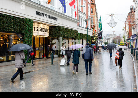 Dublino, Irlanda. 21 NOV 2018: Freddo e piovoso giorno a Dublino come acquirenti e turisti che si nasconde sotto gli ombrelloni passeggiare intorno a Grafton Street cercando inizio venerdì nero offerte. Credito: Michael Grubka/Alamy Live News Foto Stock