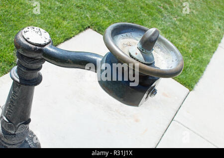 Un rame fontana potabile vicino a erba verde. Foto Stock