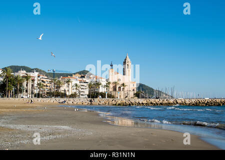 La bella città di Sitges con i gabbiani, inverno Spagna, paesaggio del litorale a Sitges, Parròquia de Sant Bartomeu mi Santa Tecla Foto Stock