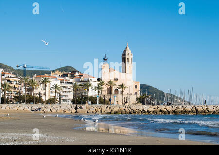 La bella città di Sitges con i gabbiani, inverno Spagna, paesaggio del litorale a Sitges, Parròquia de Sant Bartomeu mi Santa Tecla Foto Stock