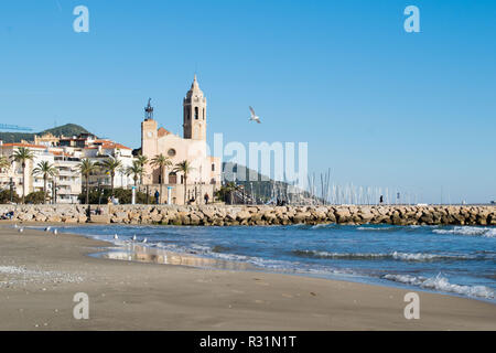 La bella città di Sitges con i gabbiani, inverno Spagna, paesaggio del litorale a Sitges, Parròquia de Sant Bartomeu mi Santa Tecla Foto Stock