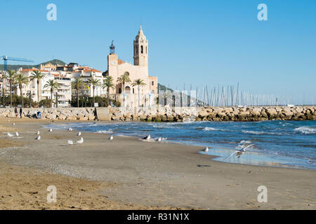 La bella città di Sitges con i gabbiani, inverno Spagna, paesaggio del litorale a Sitges, Parròquia de Sant Bartomeu mi Santa Tecla Foto Stock