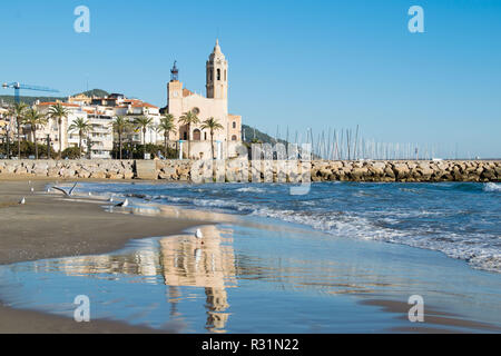 La bella città di Sitges con i gabbiani, inverno Spagna, paesaggio del litorale a Sitges, Parròquia de Sant Bartomeu mi Santa Tecla Foto Stock