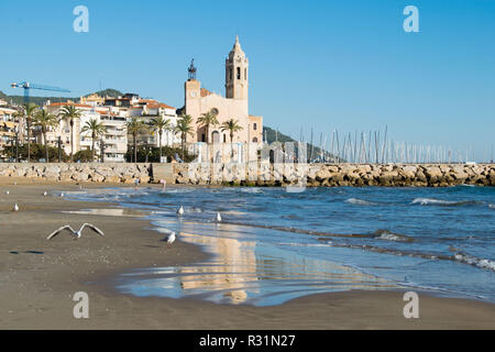 La bella città di Sitges con i gabbiani, inverno Spagna, paesaggio del litorale a Sitges, Parròquia de Sant Bartomeu mi Santa Tecla Foto Stock