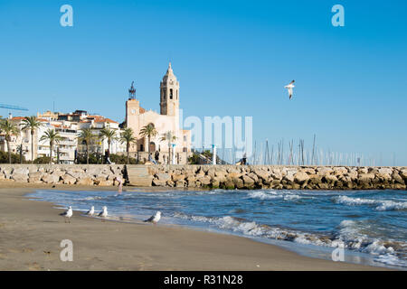 La bella città di Sitges con i gabbiani, inverno Spagna, paesaggio del litorale a Sitges, Parròquia de Sant Bartomeu mi Santa Tecla Foto Stock