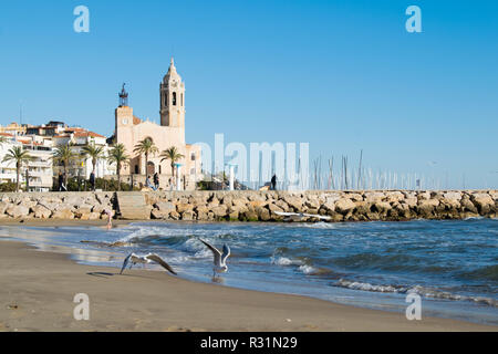 La bella città di Sitges con i gabbiani, inverno Spagna, paesaggio del litorale a Sitges, Parròquia de Sant Bartomeu mi Santa Tecla Foto Stock