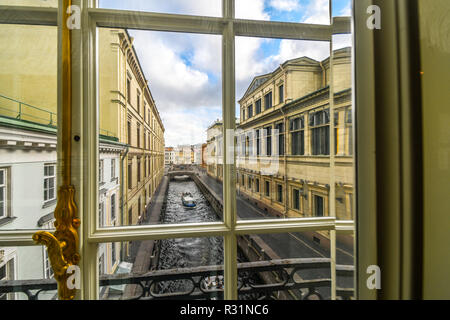 Un tour in barca scivola giù il Zimnyaya Kanavka Inverno Canal e il fiume Neva a San Pietroburgo Russia, vista da una finestra della galleria all'interno dell'Hermitage Foto Stock