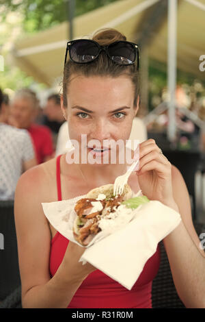 Ragazza o donna mangiare panino giroscopi. Ragazza con piacere mangia burger dopo la dieta. Foto Stock