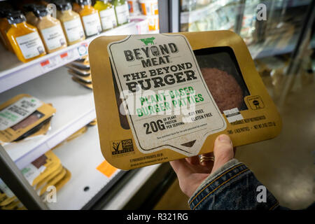 Un acquirente sceglie un pacchetto di oltre le carni provenienti da un congelatore in un supermercato a New York lunedì 19 novembre, 2018. La pianta-proteina basato su start-up al di là di carne ha archiviato per un'offerta pubblica iniziale per 100 milioni di dollari. Il mercato globale dei sostituti della carne è prevista crescere a $ 6,4 miliardi di euro per l'anno 2023, attualmente è stimato a $ 4,6 miliardi. (© Richard B. Levine) Foto Stock