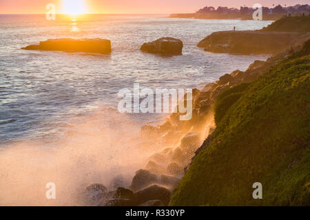 La frantumazione delle onde sulla costa rocciosa al tramonto, Santa Cruz, in California Foto Stock