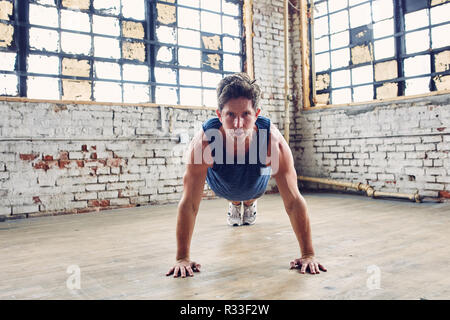 Uomo caucasico funziona facendo Ups Push Foto Stock