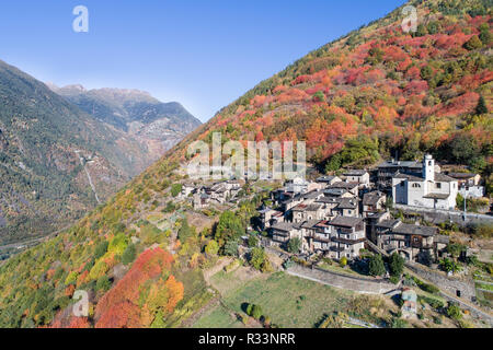 Autunno in Valtellina, piccolo villaggio. Le vecchie case con la chiesa Foto Stock