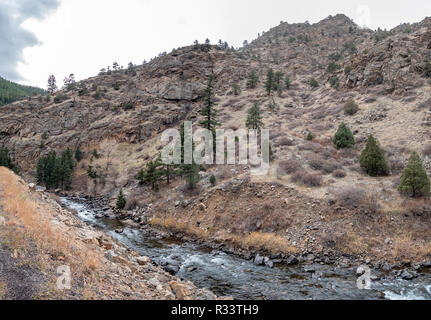 Vista del ruscello di montagna che scorre accanto a Tall Rocky Mountain Foto Stock