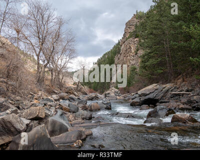 Basso angolo vista di acqua che scorre a valle tra due colline Foto Stock