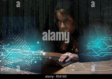 Ritratto di donna in nero hoodie utilizzando laptop, cyber security concept Foto Stock