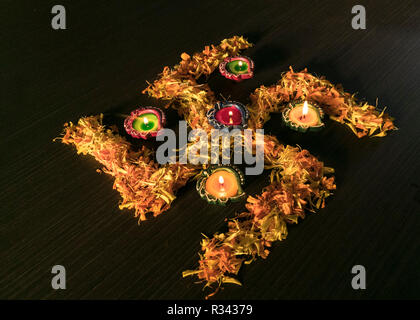 Cinque colorate diyas illuminato posto su swastik per celebrare diwali e dhanteras festival in India Foto Stock