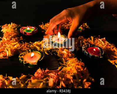 Una ragazza diyas illuminazione per celebrare diwali e dhanteras festival in India Foto Stock