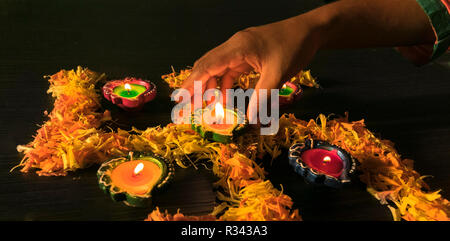 Una ragazza diyas illuminazione per celebrare diwali e dhanteras festival in India Foto Stock