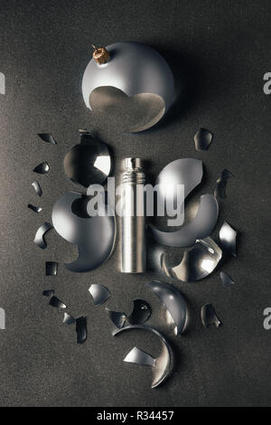 Vista superiore del profumo e rotture di argento Pallina natale su grigio Foto Stock