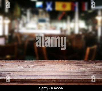 Tavolo in legno con sfondo blured cafe , per la tua foto montaggio o il display del prodotto. Spazio per appoggiare oggetti sul tavolo. Foto Stock