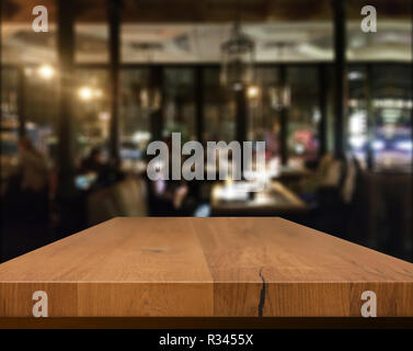 Tavolo in legno con sfondo blured cafe , per la tua foto montaggio o il display del prodotto. Spazio per appoggiare oggetti sul tavolo. Foto Stock