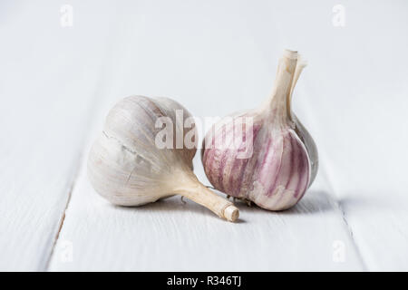 Due teste d'aglio bianco sul tavolo di legno Foto Stock