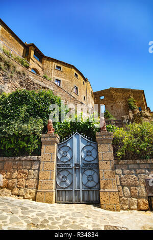 Facciata di una casa di pietra con un cancello di ferro del borgo di Civita di Bagnoregio, Viterbo, Lazio, Italia Foto Stock