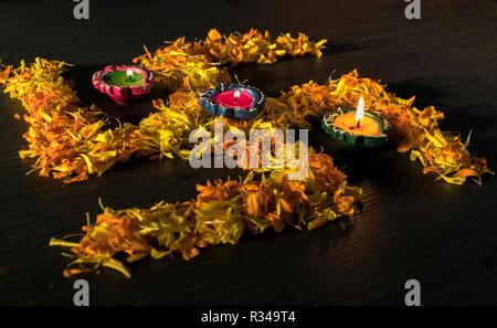 Illuminata diya collocato su fiori gialli per celebrare diwali e dhanteras festival in India Foto Stock