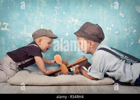 Due fratelli giocare con volantino in legno Foto Stock