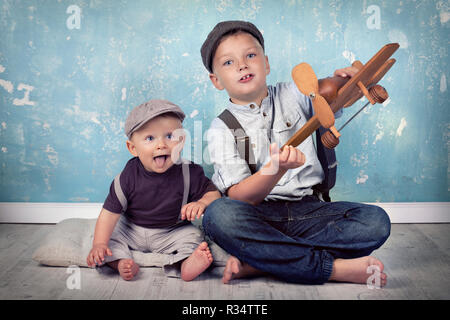 Due fratelli giocare con volantino in legno Foto Stock