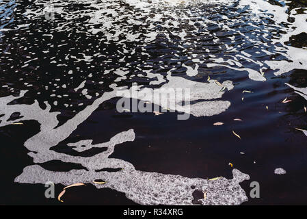 Acqua con schiuma contaminate da detergenti in un fiume, prendersi cura dell'ambiente. Foto Stock