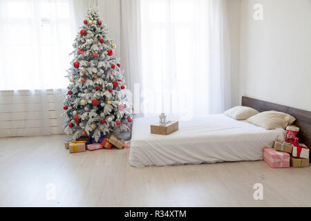 Albero di natale in camera da letto con letto matrimoniale e di doni vacanza anno nuovo cartolina invernale Foto Stock