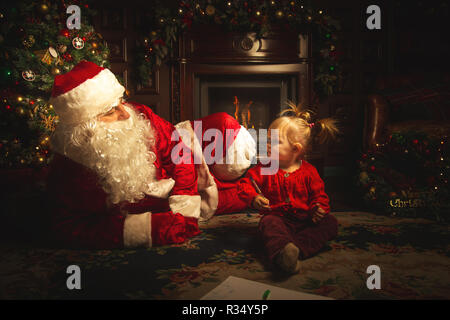 Vero Babbo Natale è giocare con i bambini nei pressi di un albero di Natale. L'atmosfera di festa e di magia. Foto Stock