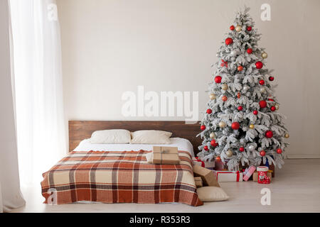 Albero di natale in camera da letto con letto matrimoniale e di doni vacanza anno nuovo cartolina invernale Foto Stock