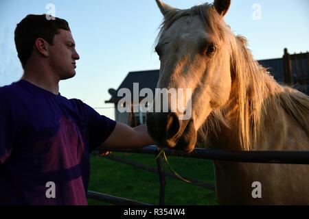 Un giovane uomo appeso fuori con il suo cavallo Foto Stock