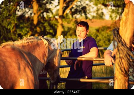 Un giovane uomo appeso fuori con il suo cavallo Foto Stock