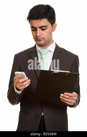 Bel giovane imprenditore persiano holding clipboard mentre usando Foto Stock
