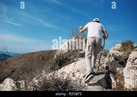 Un giovane uomo è impegnato in escursionismo Foto Stock