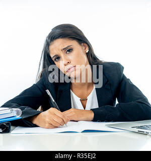 Attraente giovane imprenditrice disperata e frustrato lavorando sul computer portatile in ufficio nelle ore di lavoro straordinario e non adempimento di quelle speranze o professi Foto Stock