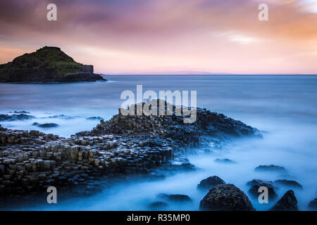 Una lunga esposizione di alba attraverso il Selciato del gigante in Bushmills, Irlanda del Nord Foto Stock