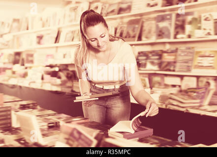 Donna acquistare libri in copertina rigida in bookstore Foto Stock