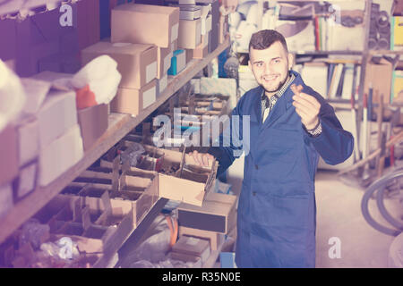 Lavoratore positivo controllo piccoli dettagli per ingegneria sanitaria in officina Foto Stock