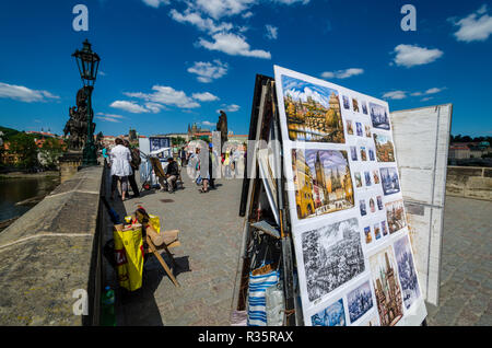 Vari artisti vendere la loro arte sul ponte storico 'Karlův piu', il Ponte di Carlo, attraversando il fiume Moldava'. Il 'Hradčany' in background Foto Stock