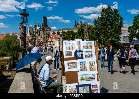 Vari artisti vendere la loro arte sul ponte storico 'Karlův piu', il Ponte di Carlo, attraversando il fiume Moldava'. Il 'Hradčany' in background Foto Stock