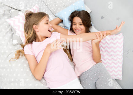 Slumber party concetto. Le ragazze vogliono semplicemente divertirsi. Invita un amico per sleepover. Migliori amici per sempre. Considerare il tema slumber party. Slumber party intramontabile tradizione di infanzia. Ragazze rilassante sul letto. Foto Stock