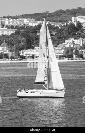 Lisbona, Portogallo - 03 Aprile 2010: barca a vela in mare sul paesaggio urbano. Barca a vela con vela bianca vela lungo la costa del mare. Avventura estate e vacanza attiva. Yacht a vela e wanderlust. Foto Stock